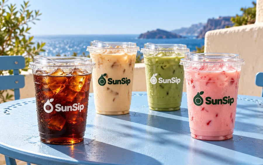 Clear PET cups with colorful iced drinks and printed SunSip logos in a summer outdoor setting.