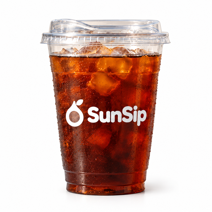 Light logo print on a clear cup filled with a dark iced drink