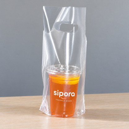 Clear PE single-cup takeaway bag with die-cut handle holding a lidded orange lemon tea.