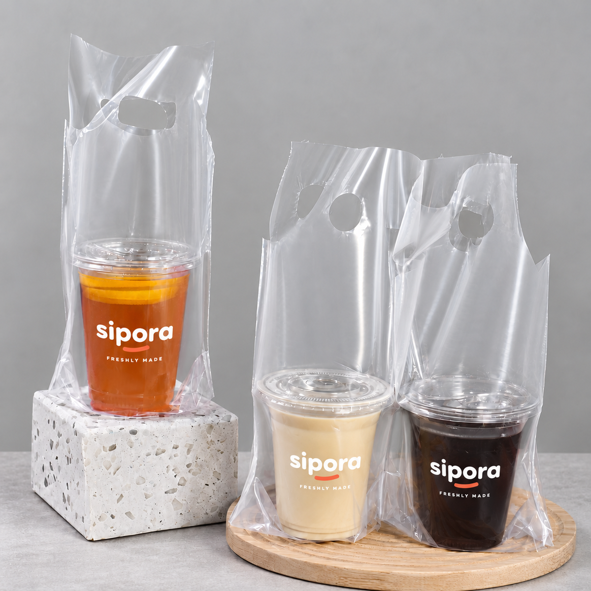 Clear PE takeaway bags shown with one orange tea cup and two separate coffee drinks.